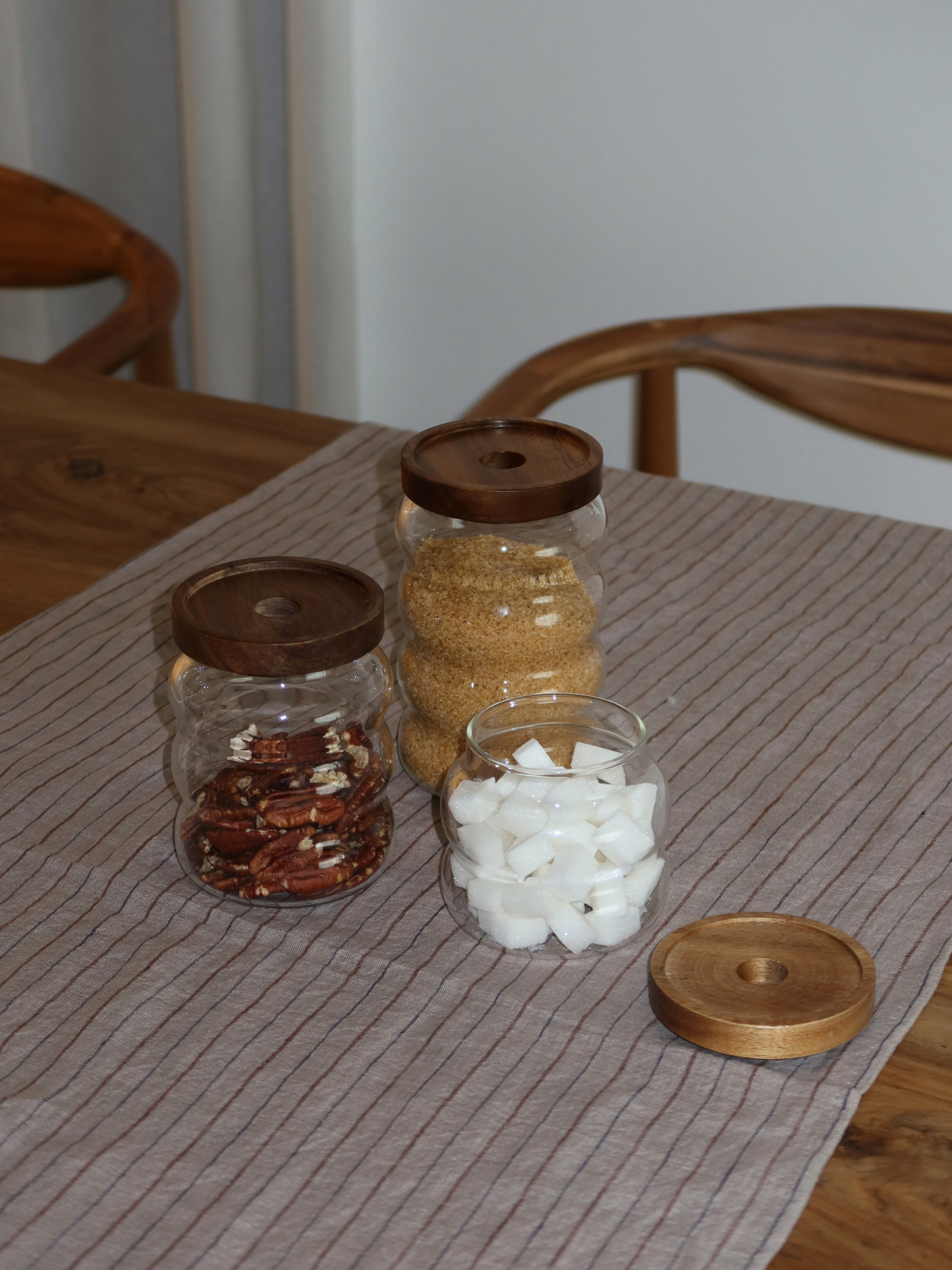 wavy round storage jar acacia lid, round storage jar with wavy shape, wavy glass storage jar, storage jar with acacia wooden lid, storage jar brown lid, storage jar with natural wooden lid, airtight storage jar, storage jar stylish design, storage jar with screw lid, transparent storage jar, storage jar kitchen organizing, storage jar set, storage jar small and large, storage jar with label, storage jar bamboo alternative, storage jar kitchen cabinet, storage jar sustainable material
