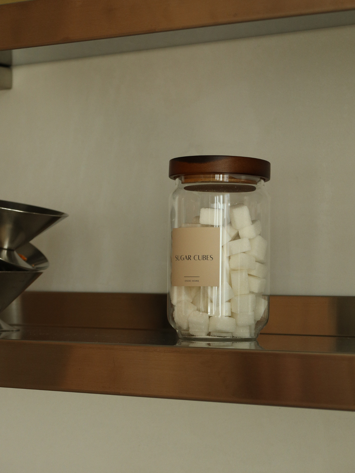 Airtight glass pantry jar Nour with dark brown acacia wood lid for elegant kitchen and pantry organization, made from toxin-free, PFAS-free and BPA-free materials, perfect for storing pasta, rice, coffee, snacks and dry foods in a stylish and organized way, featuring a transparent glass canister design with a thick natural acacia wooden lid and available in four different sizes for modern countertop styling and minimalist kitchen storage.