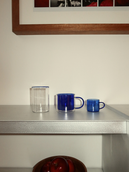 Blaues doppelwandiges Glas für Tee und Kaffee aus langlebigem, hitzebeständigem Borosilikatglas. Das elegante Soo-ah Glas überzeugt mit einem satten Blauton und zeitlosem Design und ist eine stilvolle Ergänzung für moderne Küchen und Kaffeebereiche. Die Doppelwand hält Heißgetränke länger warm und sorgt gleichzeitig dafür, dass die Außenseite angenehm in der Hand bleibt. Ideal als Teeglas, Kaffeeglas oder Trinkglas für warme Getränke. Langlebig, wiederverwendbar und einzeln erhältlich.
