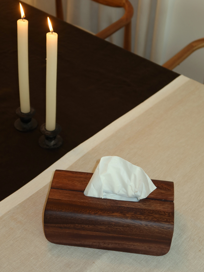 Boîte à mouchoirs en bois Tian, fabriquée à la main à partir de bois naturel de Bornéo avec une finition brun foncé chaleureuse. Conçue pour dissimuler et organiser élégamment les boîtes de mouchoirs standards, cette boîte minimaliste avec couvercle apporte chaleur et élégance à tout intérieur. Idéale pour la salle de bain, la chambre, le salon ou le bureau, elle permet de créer un espace calme et bien organisé. Un accessoire de maison durable et intemporel en bois, au style naturel.