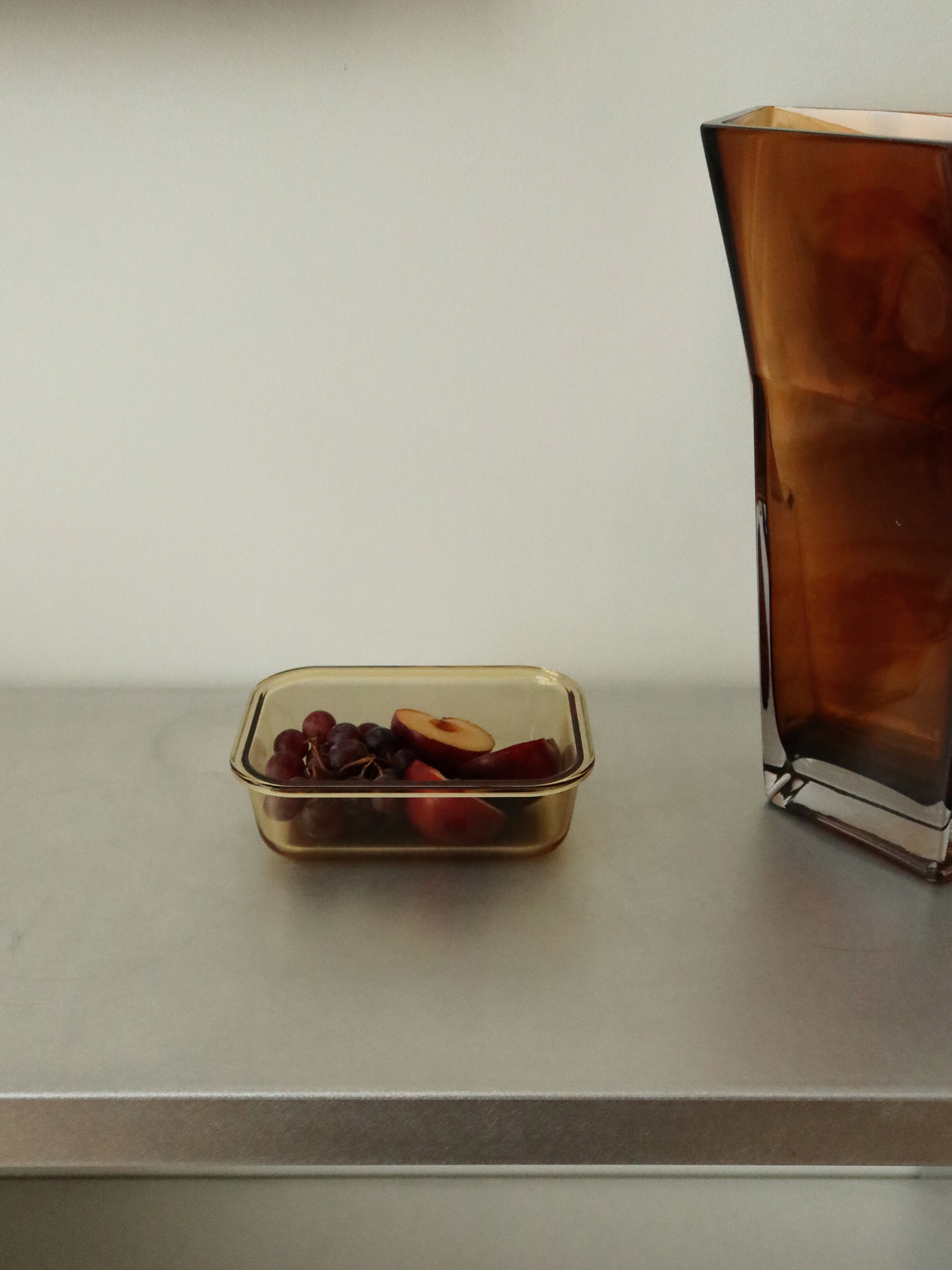 Organisiertes Aufbewahren mit Stil – das ist Tamar, hergestellt aus bernsteinfarbenem Glas und versehen mit einem Holzdeckel. Funktional und stilvoll, ideal für alle, die bewusst aufbewahren, aufwärmen und organisieren möchten. Erhältlich in drei Größen: Die kleinste Größe ist perfekt für Joghurt, Nüsse oder einen Snack. Die Glasschale (ohne Deckel) ist ofenfest, sodass Mahlzeiten direkt aufgewärmt werden können. PFAS-frei, schadstofffrei und ohne BPA. Borosilikatglas.