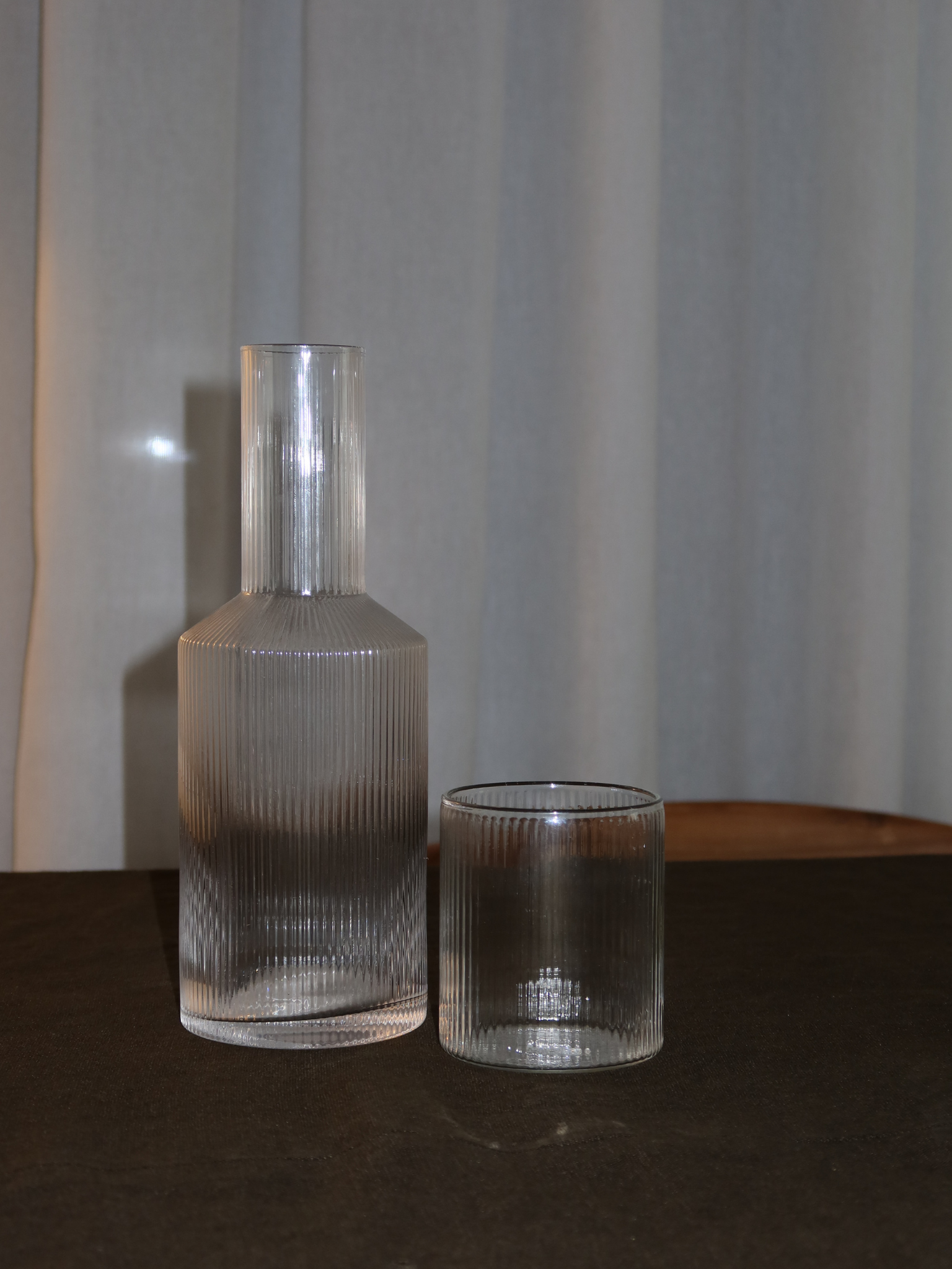 Pour Bottle Neko, an elegant water or juice pitcher with a subtle ribbed texture that beautifully captures light and shadow. Perfect for serving water, juice, or other refreshing drinks in style. Made from durable, clear borosilicate glass—strong and heat-resistant—with a handy shape that makes filling and pouring easy. The ribbed structure adds a unique, playful touch without being overpowering. Pair Neko with matching glasses (sold separately) for a complete and stylish set