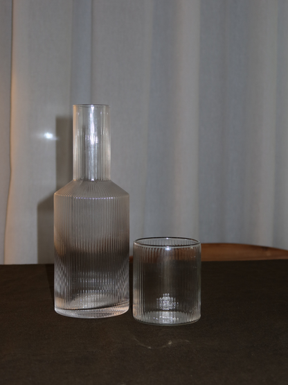 Pour Bottle Neko, an elegant water or juice pitcher with a subtle ribbed texture that beautifully captures light and shadow. Perfect for serving water, juice, or other refreshing drinks in style. Made from durable, clear borosilicate glass—strong and heat-resistant—with a handy shape that makes filling and pouring easy. The ribbed structure adds a unique, playful touch without being overpowering. Pair Neko with matching glasses (sold separately) for a complete and stylish set