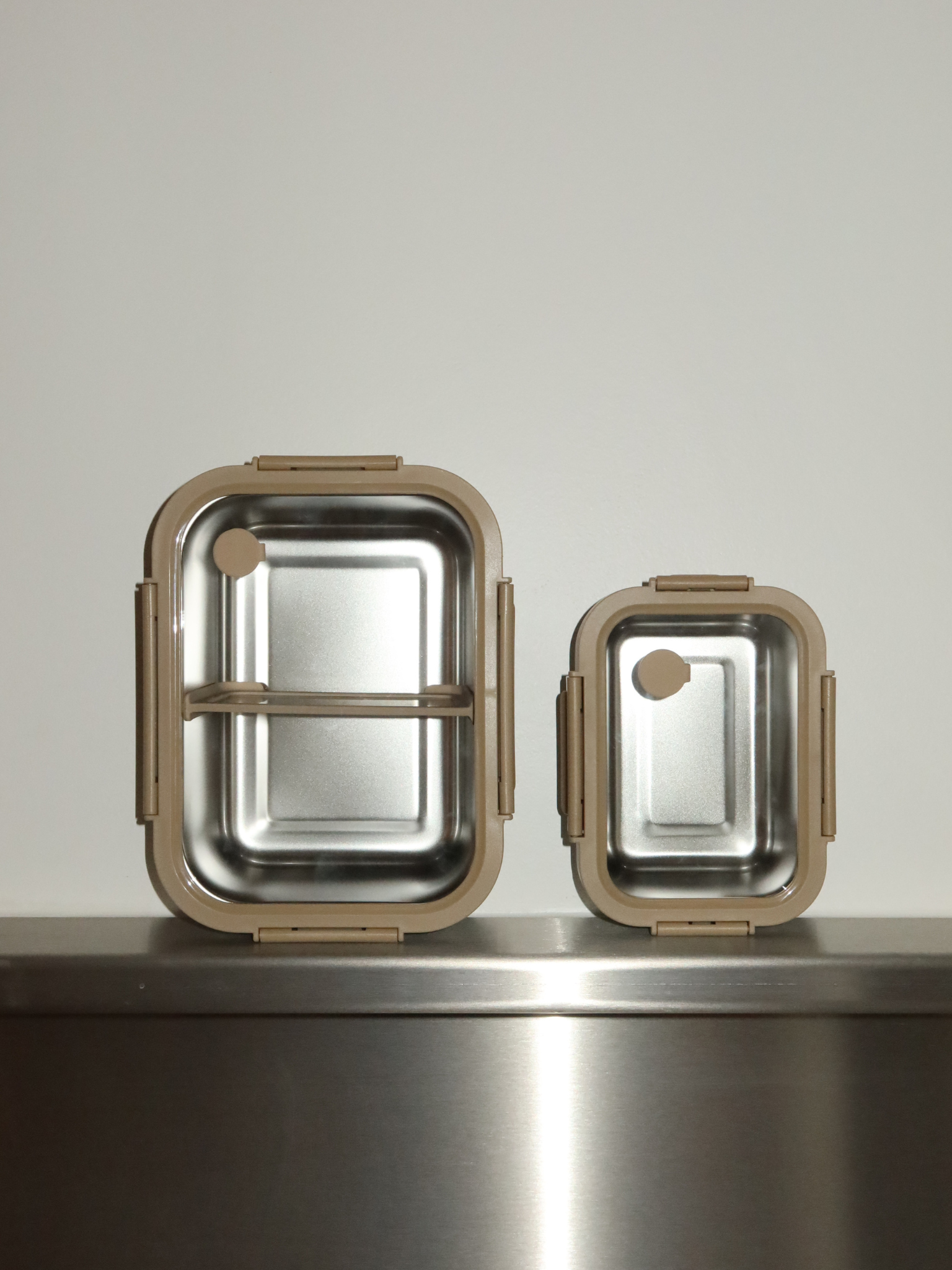 Leicht, auslaufsicher und lebensmittelsicher: Bento ist ein praktischer, dennoch eleganter Behälter aus Edelstahl mit transparentem Kunststoffdeckel, herausnehmbarem Trenner und feinen beigen Details. Sicherungsclips sorgen für einen festen Verschluss bei Meal Prep, Resten oder trockenen Zutaten. Ungiftig, BPA-frei und langlebig – Bento verbindet Einfachheit mit Funktionalität. Seine sanften Farbtöne und der durchsichtige Deckel bringen Ruhe und Stil in jede Küche, Speisekammer oder Lunchbox.