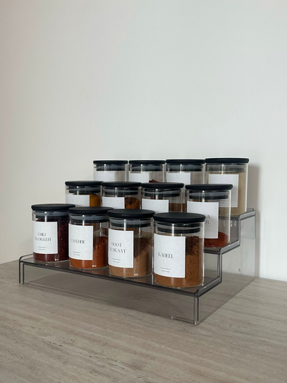 Extendable, collapsible spice rack made from clear, see-through acrylic, designed to neatly store spice jars in a kitchen drawer. This transparent acrylic spice rack creates a clean, minimal, and organized kitchen by keeping spice jars visible and easy to access. A space-saving spice organizer and drawer organizer that adjusts to different drawer sizes, helping maintain a structured and clutter-free kitchen layout. Ideal for organizing spice jars in a sleek, modern way while supporting efficient kitchen org