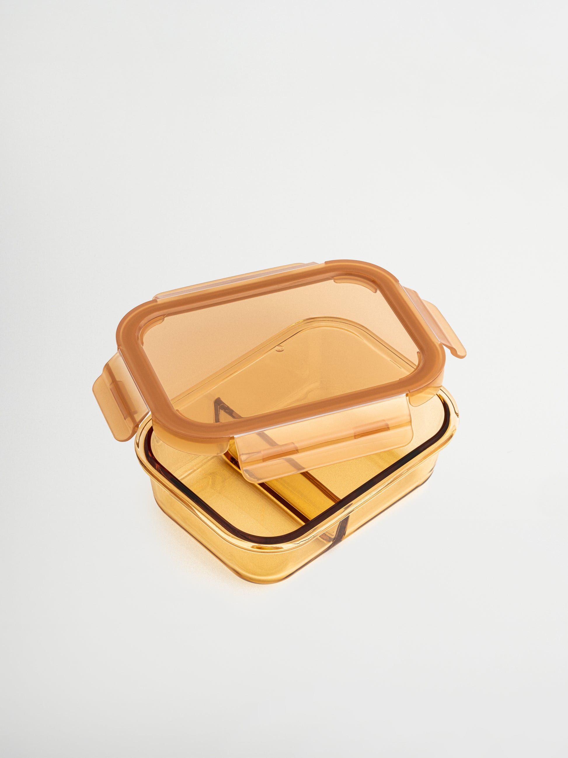 Zad est un récipient en verre ambré avec couvercle en verre et accents ambrés/bruns, alliant style et fonctionnalité. Le diviseur en verre intégré organise facilement plusieurs ingrédients. Idéal pour les déjeuners équilibrés, le meal prep ou conserver des restes. Non toxique, sans BPA, résistant aux odeurs et aux taches, durable, facile à nettoyer, étanche et parfait pour un rangement réfléchi et élégant dans cuisine, frigo ou sac de déjeuner.