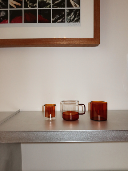 Gerades Espressoglas in einem warmen cognacbraunen Ton, ideal zum Servieren von Espressoshots oder anderen Kaffeegetränken. Das elegante, minimalistische Design verleiht Ihren Kaffeemomenten einen Hauch von Luxus und passt wunderbar in eine moderne, stilvolle Küche oder Kaffeestation. Hergestellt aus langlebigem Glas für den täglichen Gebrauch und bietet ein nachhaltiges und ästhetisches wiederverwendbares Trinkerlebnis.