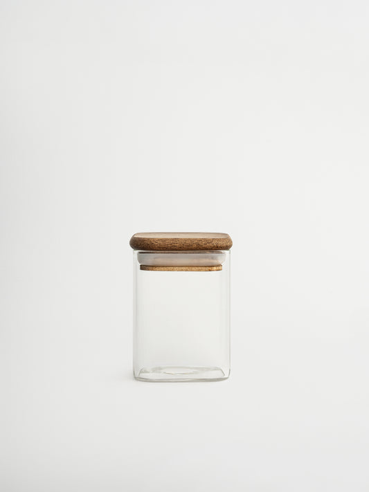 Halten Sie Ihre Kräuter ordentlich und übersichtlich mit dem Gewürzglas Kai. Dank des cleveren quadratischen Formats behalten Sie sofort den Überblick über Ihre Gewürze, was das Kochen schneller und einfacher macht. Das durchsichtige Glasgefäß besteht aus robustem Glas und ist mit einem quadratischen Akazienholzdeckel mit Gummidichtung ausgestattet, der die Kräuter lange frisch hält. Zeitlos, praktisch und gestaltet, um Ihrer Küche eine frische, stilvolle Ausstrahlung zu verleihen. Ideal kombinierbar mit pe