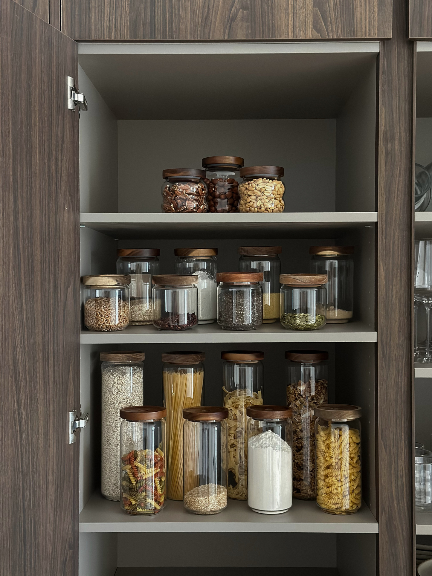 Luftdichtes Glas-Vorratsglas Nour mit dunkelbraunem Akazienholzdeckel für stilvolle Küchen- und Vorratsorganisation, hergestellt aus schadstofffreien, PFAS-freien und BPA-freien Materialien, perfekt zur Aufbewahrung von Pasta, Reis, Kaffee, Snacks und trockenen Lebensmitteln auf elegante und organisierte Weise, mit transparentem Glasbehälter und stabilem natürlichem Akazienholzdeckel, erhältlich in vier verschiedenen Größen für modernes Küchen-Styling und minimalistische Vorratshaltung.
