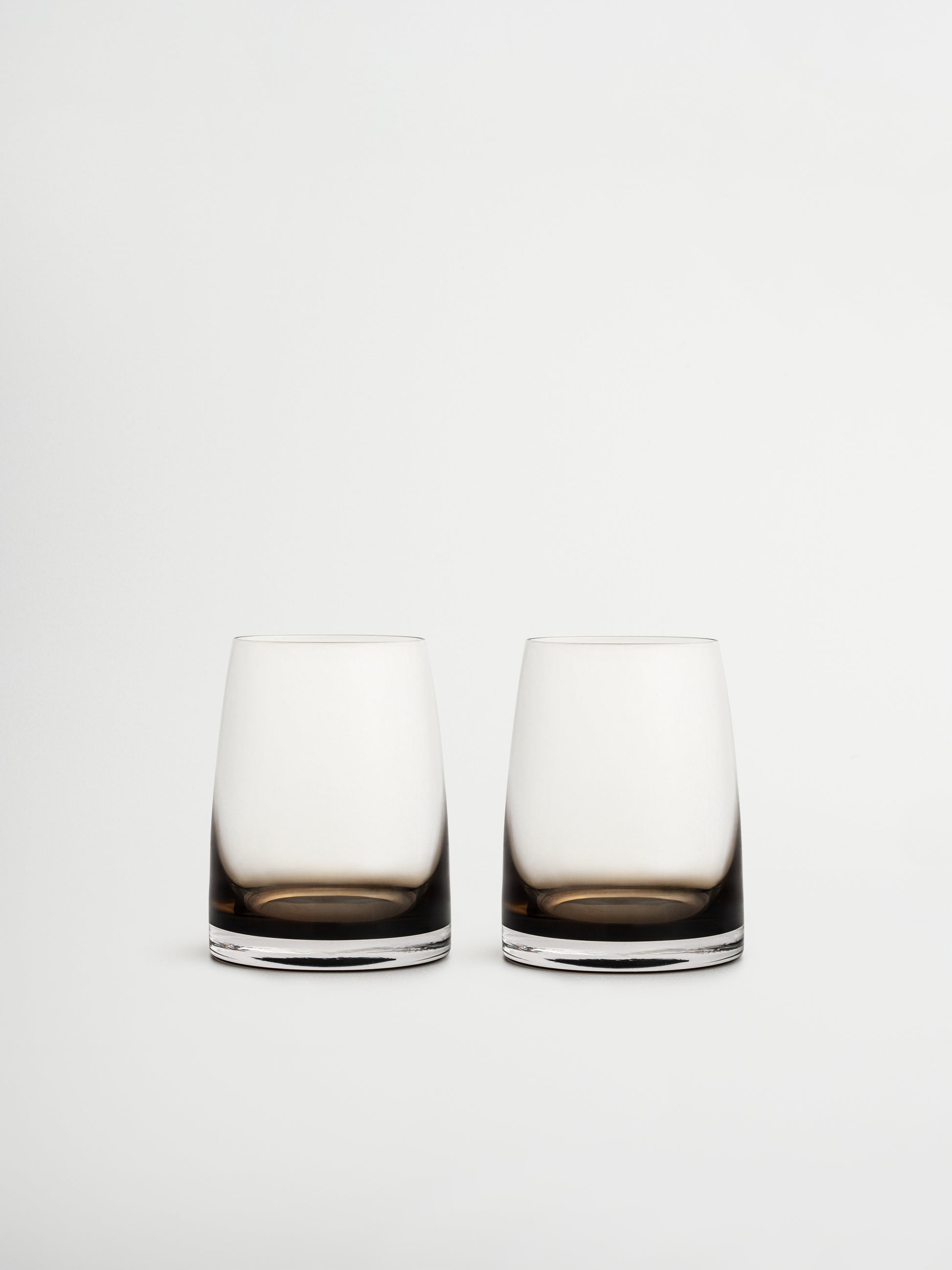 Tumbler glas Izzah met elegant ombre-effect van donkerbruin naar transparant glas, perfect om water, sap of andere verfrissende dranken stijlvol te serveren. Het minimalistische, slanke ontwerp geeft een verfijnde, restaurantachtige sfeer aan je tafel of koffiecorner. Gemaakt van duurzaam, herbruikbaar glas en ideaal voor esthetische drinkware, moderne keukens en stijlvolle tafeldecoratie.