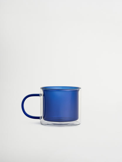 Zeg vaarwel tegen standaard mokken en ontdek Glas Soo-ah, met een rijke, opvallende blauwe kleur die stijl en sfeer toevoegt aan je tafel zonder te overdrijven. Het tijdloze ontwerp met dubbele wand is gemaakt van duurzaam, hittebestendig borosilicaatglas, perfect voor warme dranken zonder dat het glas te heet wordt om vast te houden. Sterk en langdurig, praktisch én esthetisch. Wordt per stuk verkocht, ideaal om één te kiezen of een volledige set te verzamelen.