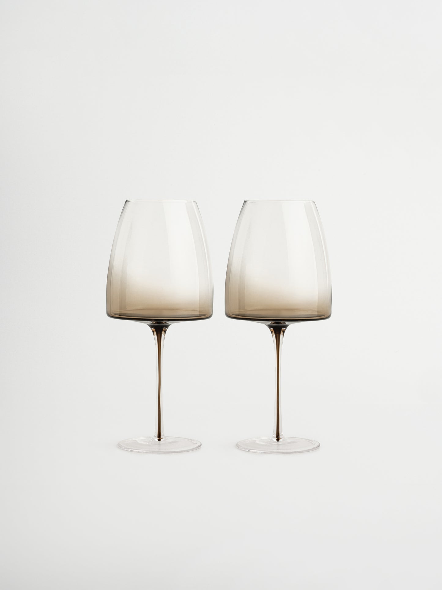 Glass Iman with a slender stem and elegant ombre effect from dark brown to transparent, perfect for adding a chic and refined touch to your wine moments. This stylish, reusable wine glass combines minimalist design with a luxurious feel, ideal for modern kitchens or restaurant-style table settings. Suitable for wine, prosecco, or other festive drinks and made from durable glass for everyday use.