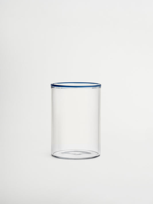 Glass Woojin, a fully transparent glass cup with a subtle blue rim that adds a stylish and unique touch to any beverage. Perfect for iced coffees, water, juices, matcha, or other refreshing drinks. Made from durable borosilicate glass with a minimalist, modern, and elegant design. Ideal for aesthetic table settings, sustainable kitchenware, and reusable glass drinkware.