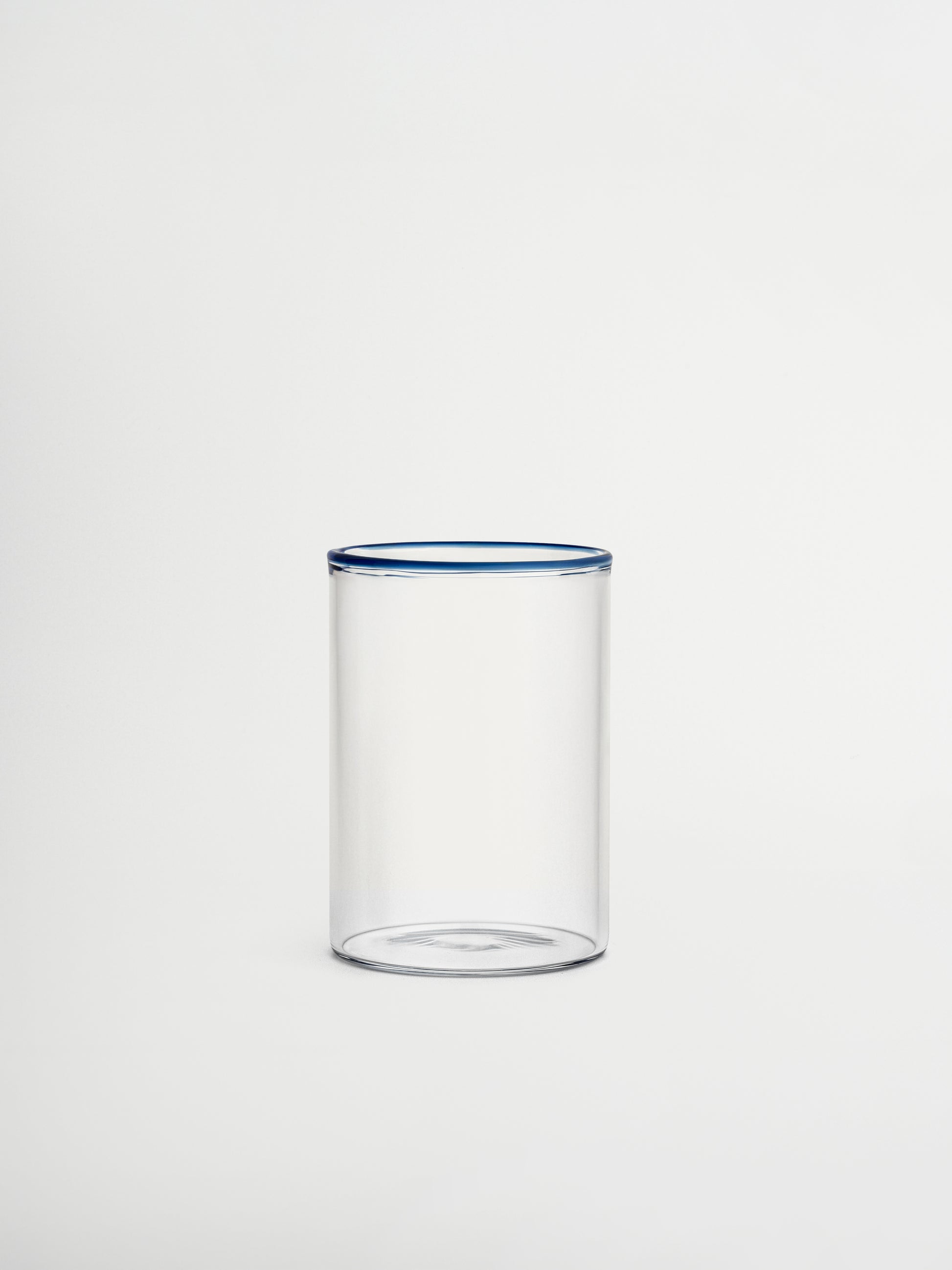 Glass Woojin, a fully transparent glass cup with a subtle blue rim that adds a stylish and unique touch to any beverage. Perfect for iced coffees, water, juices, matcha, or other refreshing drinks. Made from durable borosilicate glass with a minimalist, modern, and elegant design. Ideal for aesthetic table settings, sustainable kitchenware, and reusable glass drinkware.