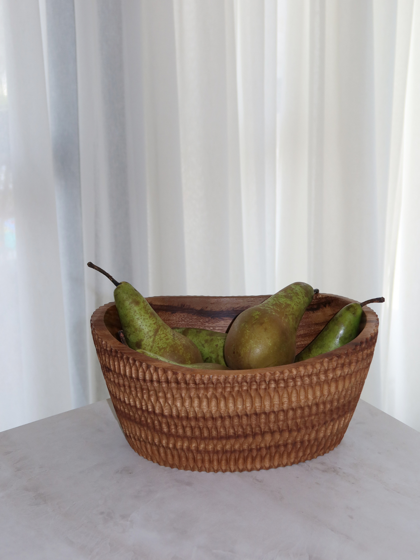 Handcrafted carved wooden fruit bowl Budi made from sustainable brown Borneo wood for elegant storage and serving of fruit, salads, snacks or large dishes, featuring a unique textured carved surface and a rich deep finish that highlights the natural wood grain, designed as a spacious and functional centerpiece for kitchen or dining table use, perfect as a stylish fruit bowl or salad serving bowl with a timeless and natural home decor aesthetic.
