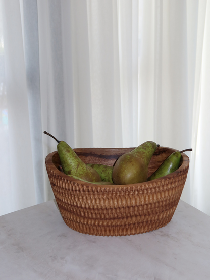 Handcrafted carved wooden fruit bowl Budi made from sustainable brown Borneo wood for elegant storage and serving of fruit, salads, snacks or large dishes, featuring a unique textured carved surface and a rich deep finish that highlights the natural wood grain, designed as a spacious and functional centerpiece for kitchen or dining table use, perfect as a stylish fruit bowl or salad serving bowl with a timeless and natural home decor aesthetic.