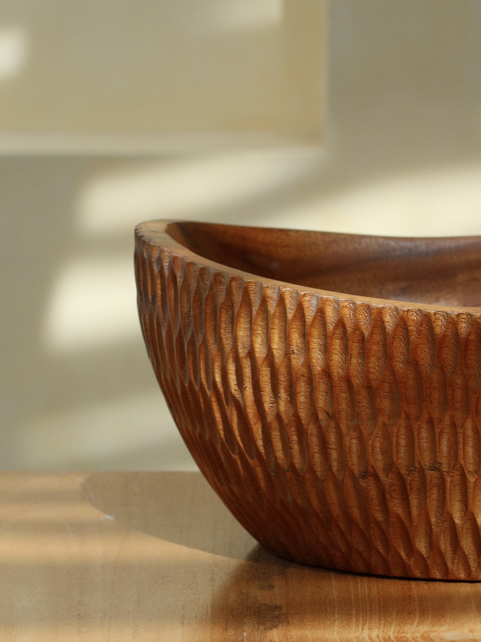 Handcrafted carved wooden fruit bowl Budi made from sustainable brown Borneo wood for elegant storage and serving of fruit, salads, snacks or large dishes, featuring a unique textured carved surface and a rich deep finish that highlights the natural wood grain, designed as a spacious and functional centerpiece for kitchen or dining table use, perfect as a stylish fruit bowl or salad serving bowl with a timeless and natural home decor aesthetic.