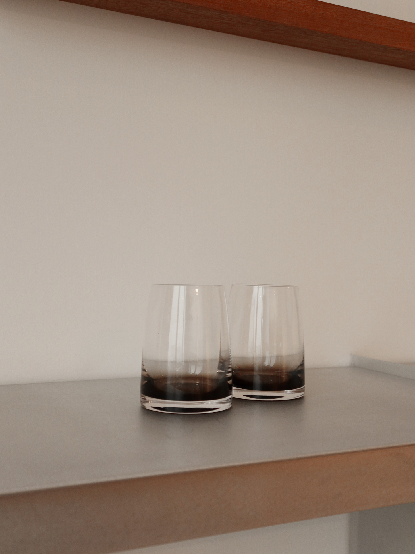 Izzah tumbler glass with an elegant ombre effect from dark brown to clear glass, perfect for serving water, juice, or other refreshing drinks in style. The minimalist, sleek design adds a refined, restaurant-like atmosphere to your table or coffee corner. Made from durable, reusable glass and ideal for aesthetic drinkware, modern kitchens, and stylish table decor.