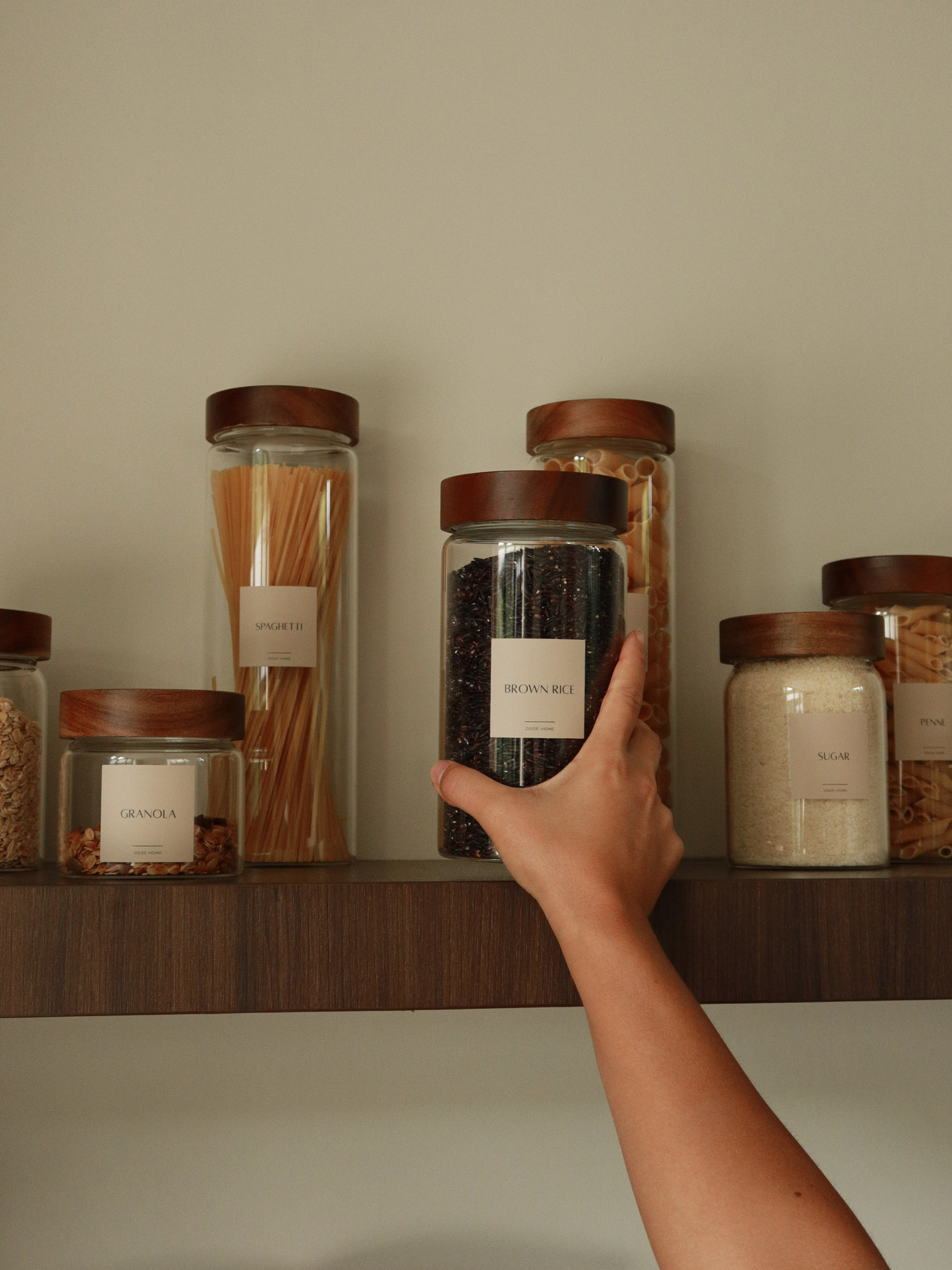 Jar Nara is designed for durability and everyday use. Made from extra-thick glass and finished with a solid acacia wood screw lid, this airtight storage jar protects dry foods while adding warmth to your kitchen shelves. Its minimalist design makes it easy to mix and match, and multiple size options allow you to organize your pantry efficiently. Elevate your kitchen storage with Jar Nara. The rich acacia wood lid and crystal-clear borosilicate-style glass create a luxurious yet natural aesthetic.