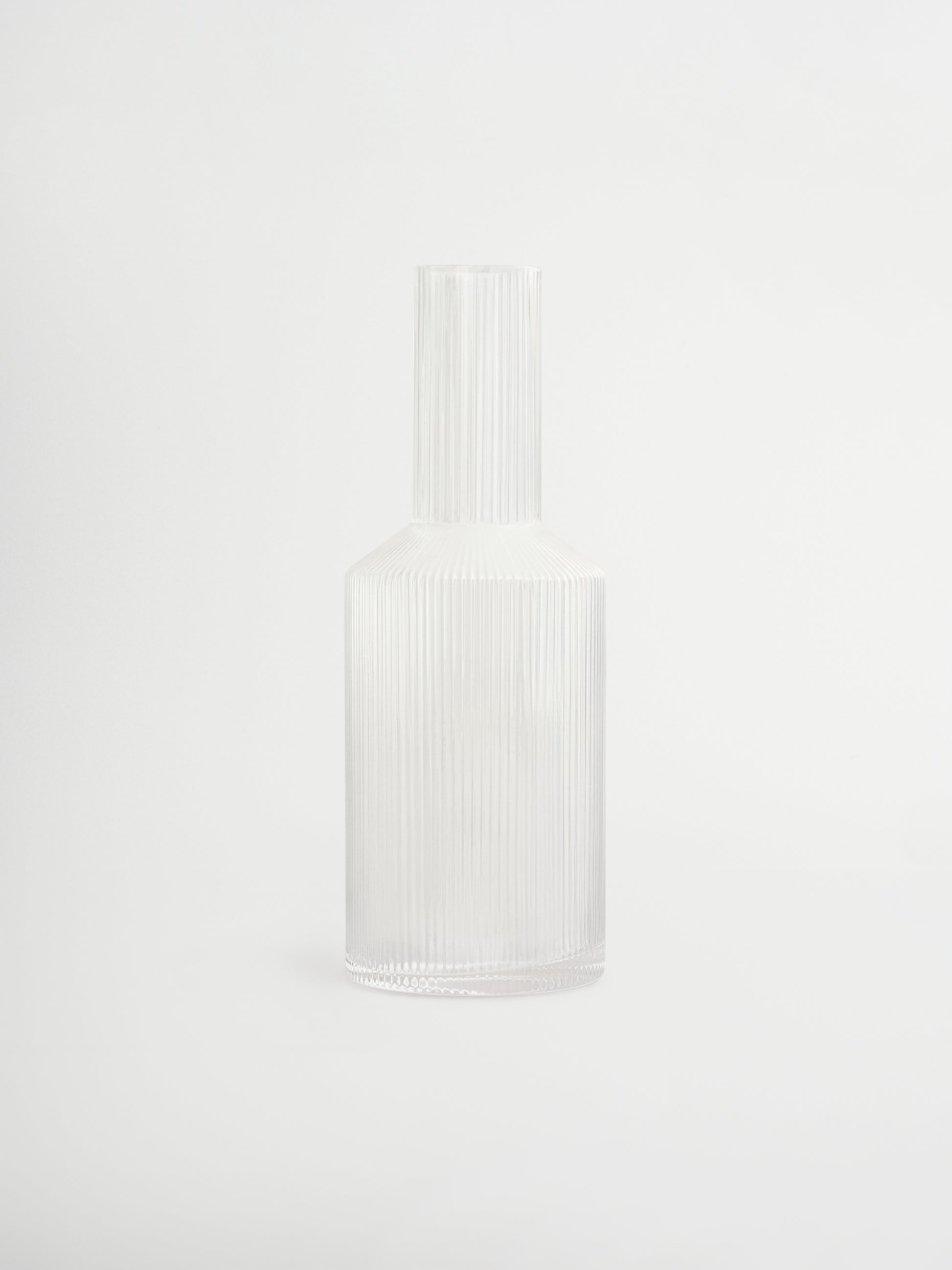 Kan Neko, een elegante water- of sapkan met subtiele ribbelstructuur die licht en schaduw prachtig vangt. Perfect om water, sap of andere verfrissende dranken stijlvol te serveren. Gemaakt van duurzaam, helder borosilicaatglas, stevig en hittebestendig, met een handzame vorm die gemakkelijk te vullen en schenken is. De ribbelstructuur geeft een unieke, speelse touch zonder te overheersen. Combineer Neko met bijpassende glazen (apart verkrijgbaar) voor een complete en stijlvolle set, of gebruik hem los. 