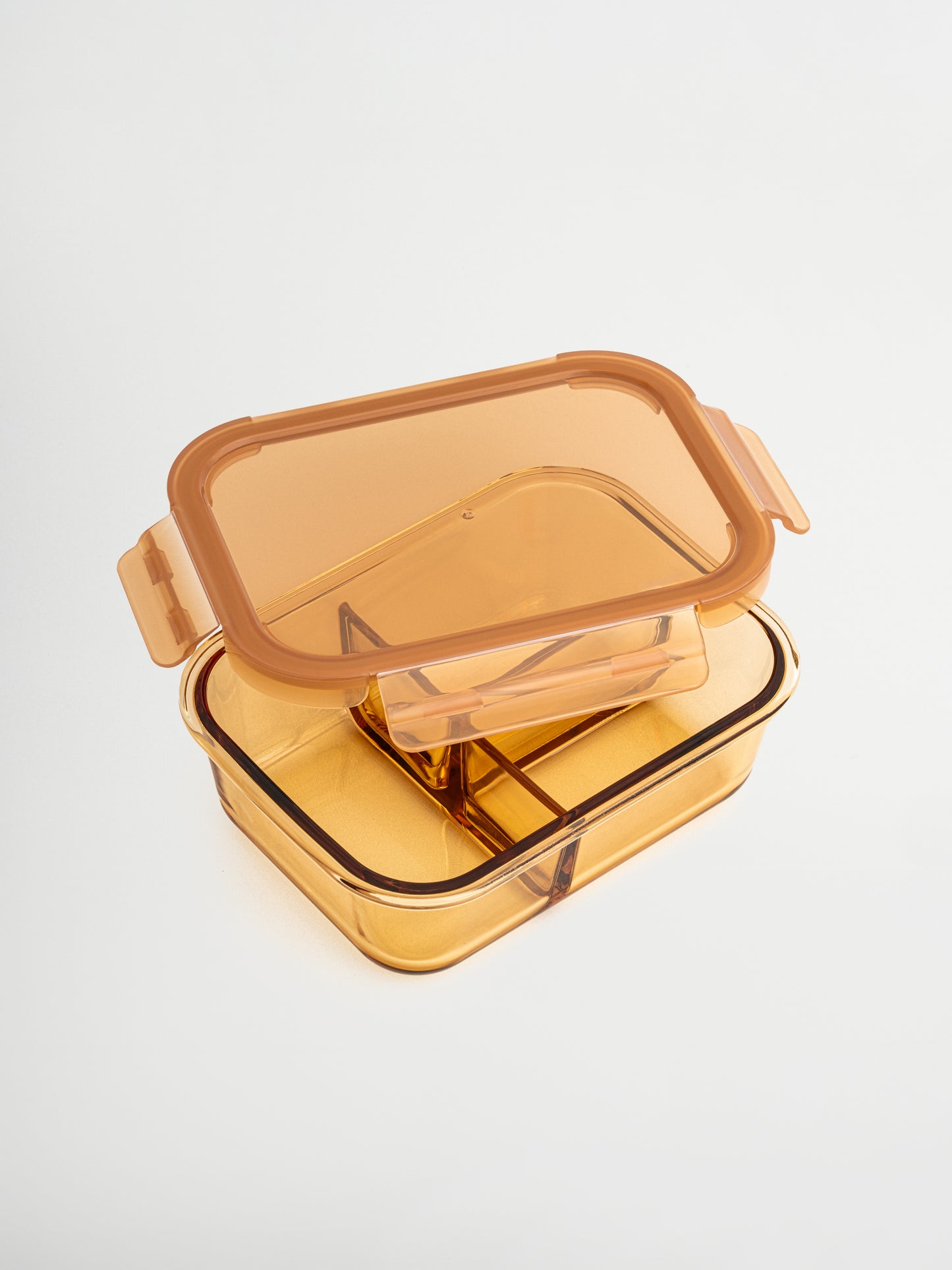 Zad ist ein Behälter aus bernsteinfarbenem Glas mit Glasdeckel und feinen Amber-/Brauntönen, der Stil und Funktion vereint. Der integrierte Glastrenner hält Zutaten organisiert. Perfekt für ausgewogene Mahlzeiten, Meal Prep oder das Aufbewahren von Resten. Ungiftig, BPA-frei, geruchs- und fleckenresistent, langlebig, leicht zu reinigen, auslaufsicher und ideal für bewusstes, stilvolles Lagern in Küche, Kühlschrank oder Lunchbox.