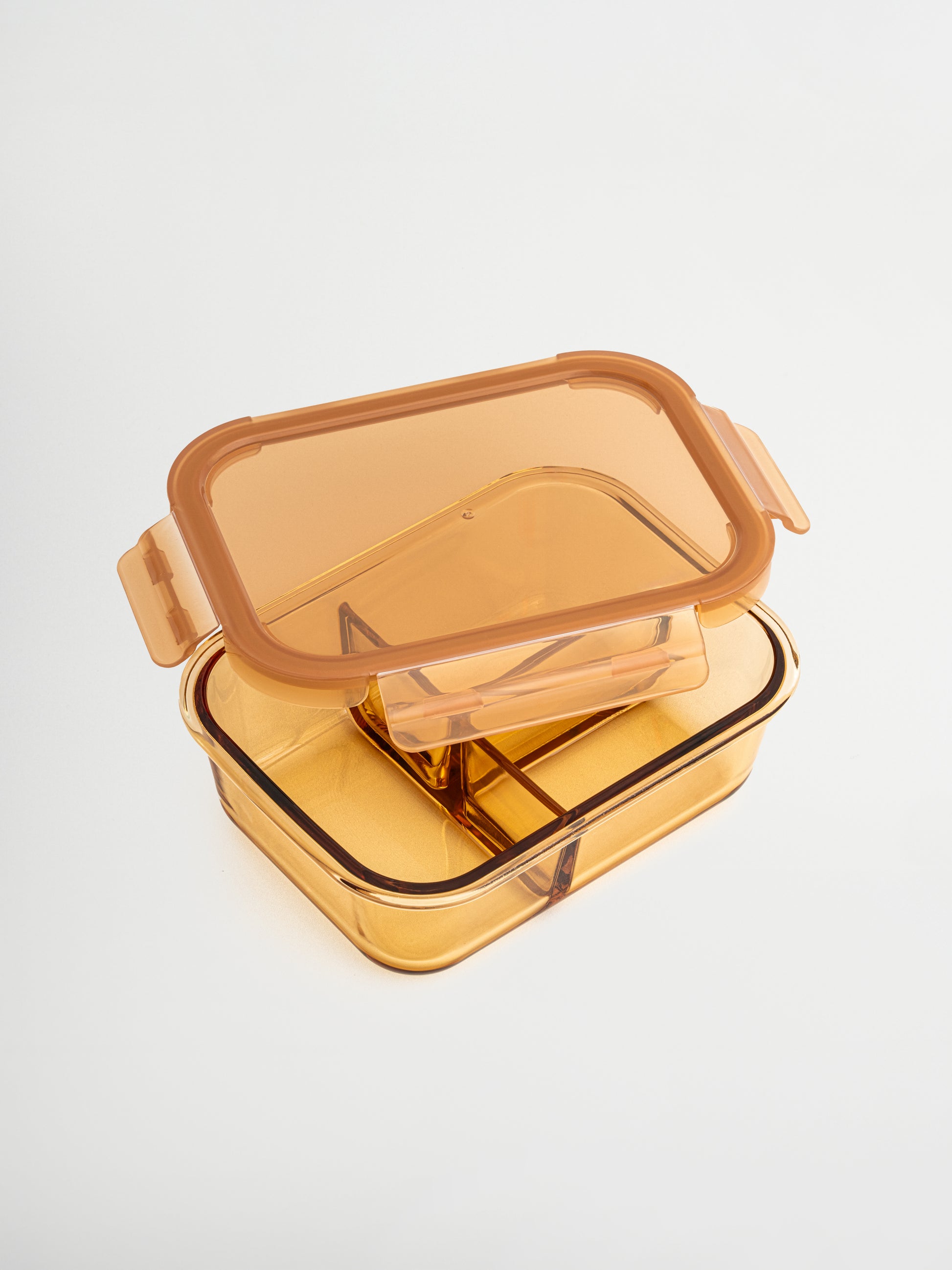 Zad ist ein Behälter aus bernsteinfarbenem Glas mit Glasdeckel und feinen Amber-/Brauntönen, der Stil und Funktion vereint. Der integrierte Glastrenner hält Zutaten organisiert. Perfekt für ausgewogene Mahlzeiten, Meal Prep oder das Aufbewahren von Resten. Ungiftig, BPA-frei, geruchs- und fleckenresistent, langlebig, leicht zu reinigen, auslaufsicher und ideal für bewusstes, stilvolles Lagern in Küche, Kühlschrank oder Lunchbox.