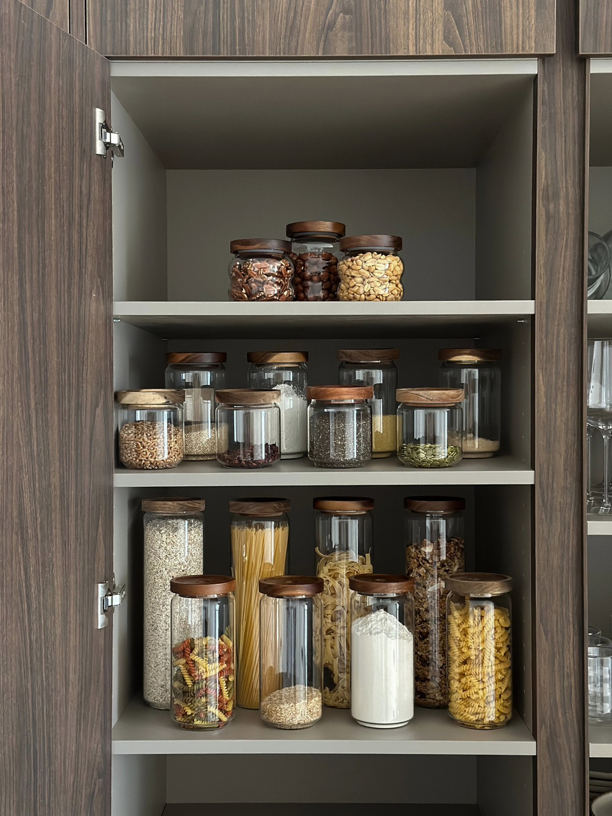 Bocal de conservation hermétique Nour en verre transparent avec couvercle en bois d’acacia brun foncé pour une cuisine et un garde-manger élégants et bien organisés, fabriqué à partir de matériaux sans substances toxiques, sans PFAS et sans BPA, idéal pour conserver les pâtes, le riz, le café, la farine, les snacks et autres aliments secs, avec un contenant en verre transparent et un couvercle épais en bois d’acacia naturel, disponible en quatre tailles pour une organisation pratique du garde-manger.