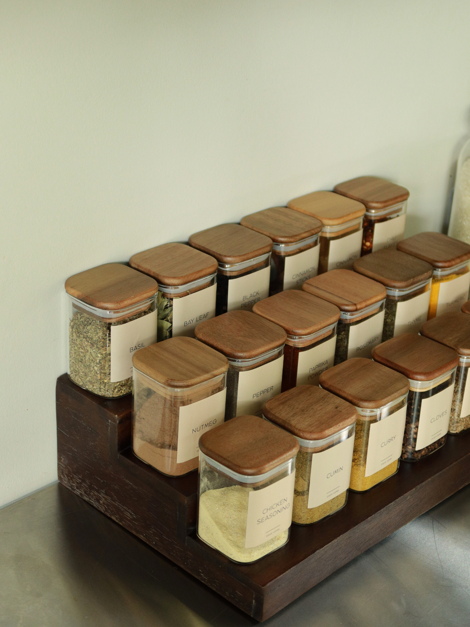 Bring calm and order to your kitchen with the Kai spice jar. Its smart square shape makes it easy to line up neatly in your cupboard or drawer, while giving you a clear overview of your herbs and spices at a glance. The clear glass jar is crafted from sturdy glass and finished with a square acacia wood lid featuring a tight rubber seal to keep contents fresh and aromatic for longer. A timeless and functional design that adds a natural, refined touch to any kitchen. Perfect to mix with other storage product.