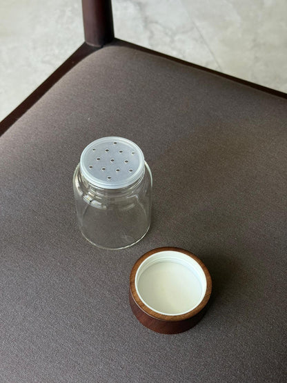 Round glass spice jar Ohm with screw cap, sprinkle lid and dark brown acacia wooden lid for organized kitchen and spice storage, made from food-safe glass and toxin-free, BPA-free and PFAS-free materials, featuring an airtight design that keeps herbs and spices fresh for longer while allowing easy seasoning during cooking, perfect for stylish spice rack organization, modern pantry storage and minimalist kitchen countertop styling.