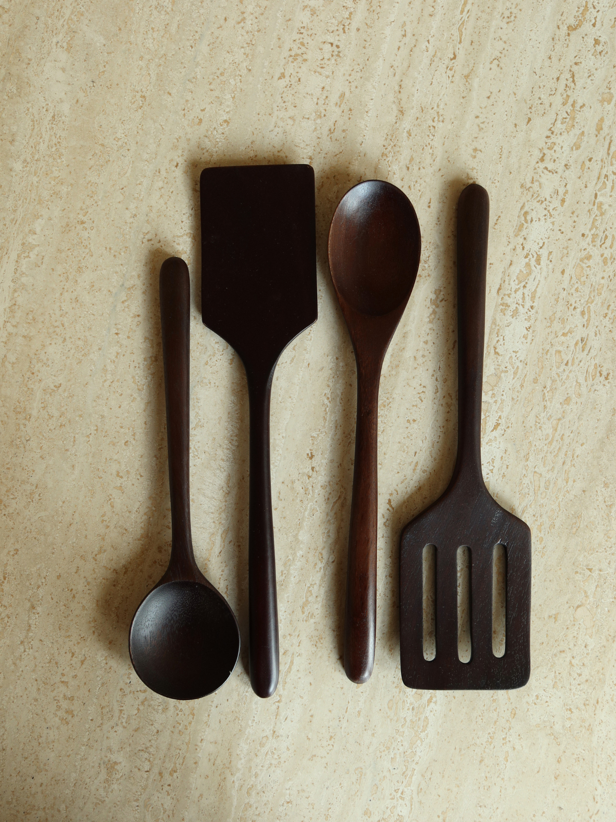 Handgefertigtes Küchenutensilien-Set aus Holz in einem tiefen Dunkelbraun, bestehend aus sechs Löffeln und Pfannenwendern zum täglichen Kochen, Mischen, Rühren, Wenden und Servieren. Gefertigt aus langlebigem, SVLK-zertifiziertem Holz aus Indonesien und für den Kontakt mit Lebensmitteln geeignet. Eine natürliche, ungiftige und plastikfreie Wahl für eine bewusste Küche. Das zeitlose Design passt perfekt zu modernen, skandinavischen, rustikalen und ländlichen Küchen.
