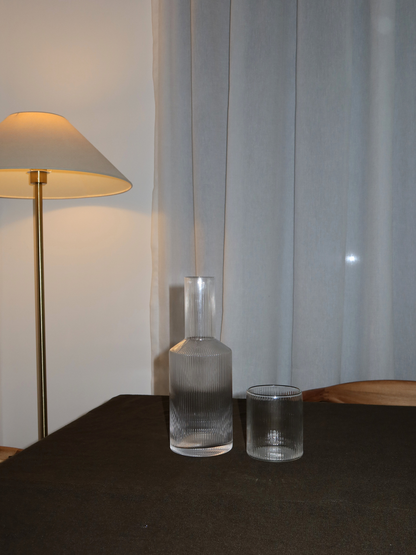 Kan Neko, an elegant water or juice pitcher with a subtle ribbed texture that beautifully captures light and shadow. Perfect for serving water, juice, or other refreshing drinks in style. Made from durable, clear borosilicate glass—strong and heat-resistant—with a handy shape that makes filling and pouring easy. The ribbed structure adds a unique, playful touch without being overpowering. Pair Neko with matching glasses (sold separately) for a complete and stylish set