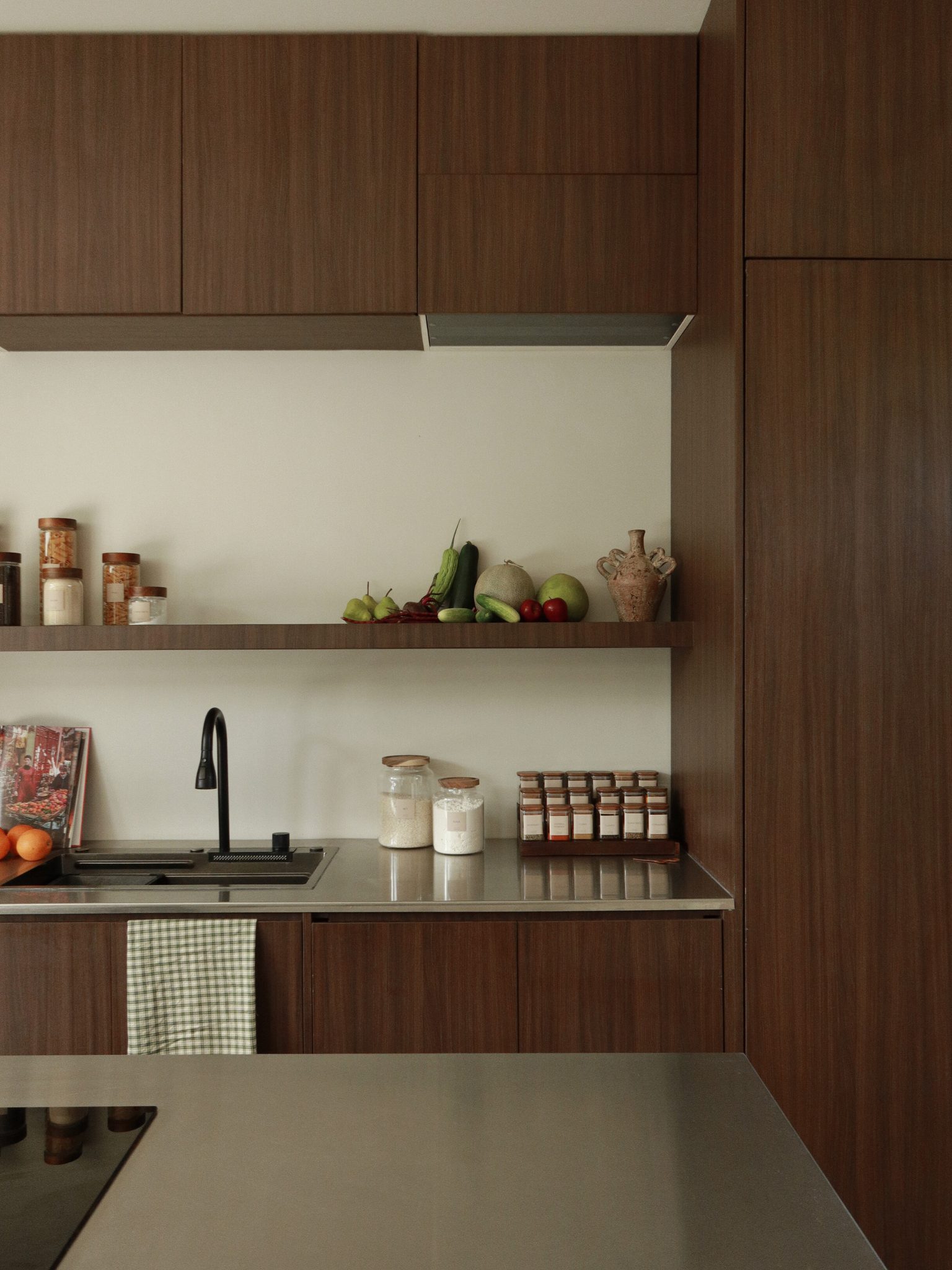 Dark brown wooden spice rack with glass jars and wooden lids, natural wood kitchen organizer for drawer storage, wooden bowl and fruit bowl, small wooden spoon and bamboo spoon, light and dark wood home organizing accessories for kitchen or bathroom. Wood organizers for kitchen or bathroom including wooden spice jars, glass storage jar with wooden lid, drawer divider and organizer in dark brown wood, wooden bowl, bamboo spoon and natural wood kitchen accessories in light or dark finish.