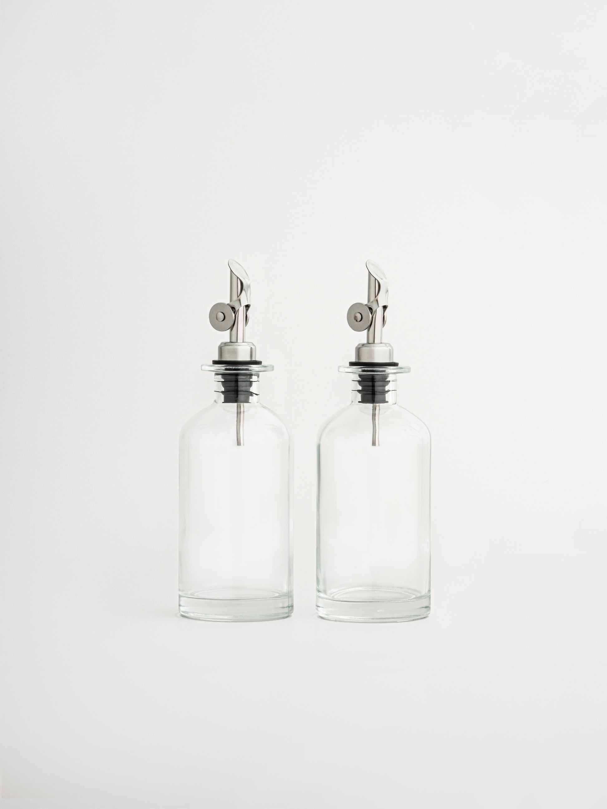 distributeur d’huile bouchon argenté, verseur de vinaigre argenté, bouteille en verre huile, bouteille vinaigre cuisine, bec verseur argent, flacon verseur en verre, accessoire cuisine moderne, bouteille hermétique huile, bec anti-goutte, flacon huile et vinaigre, distributeur en deux tailles, bouteille rangement cuisine, élégante bouteille de cuisine, set huile et vinaigre