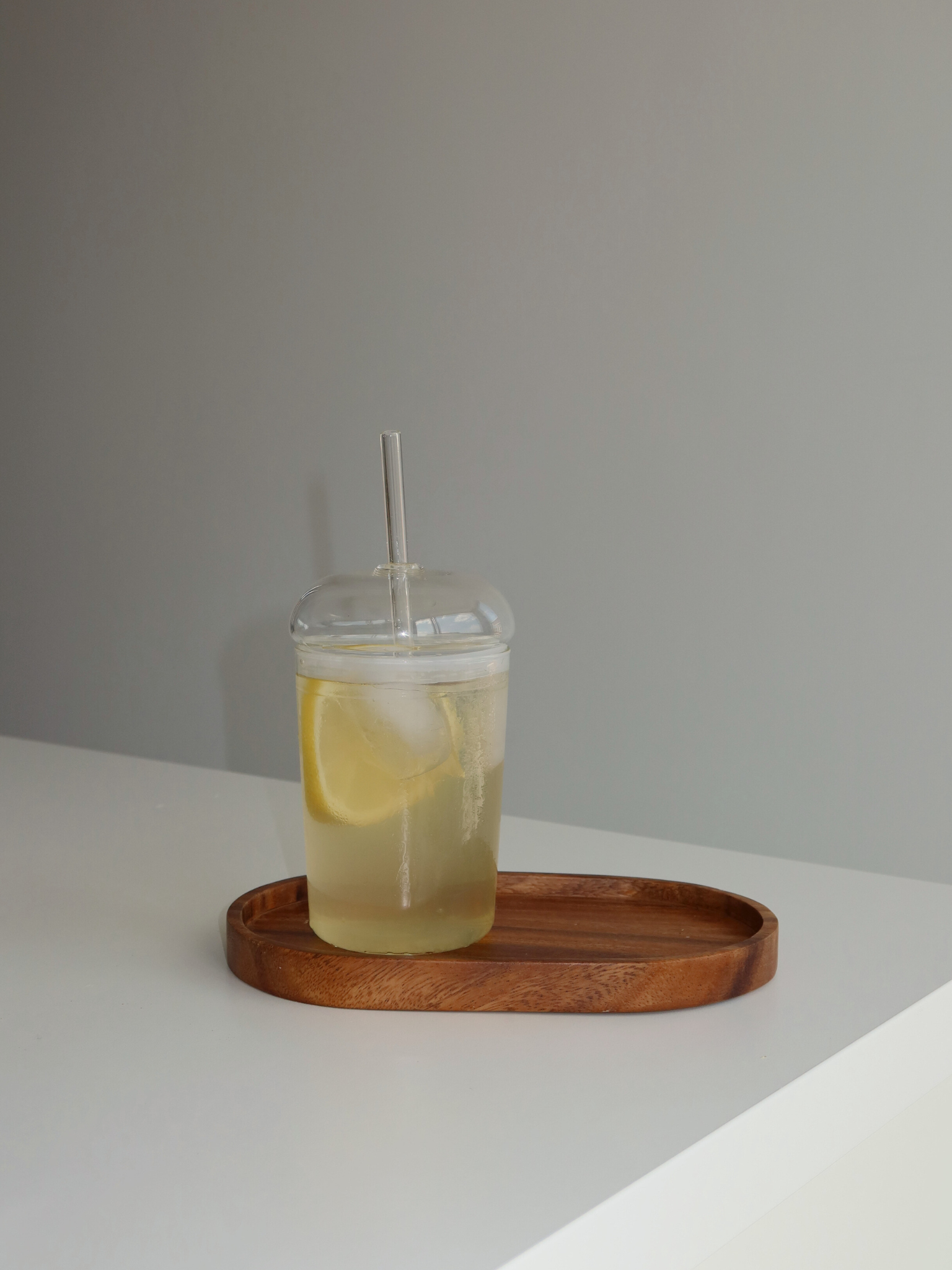 Glass cup, glass straw, clear drinkware, minimalist design, eco-friendly, reusable straw, modern tableware, transparent glass, natural light, home organization, clutter-free, tidy space, kitchen aesthetics, sustainable lifestyle, simple decor, functional kitchenware, stylish beverage, organized living, peaceful environment, elegant glassware, curated home, clean surface, thoughtful design, eco-conscious, calm ambiance.