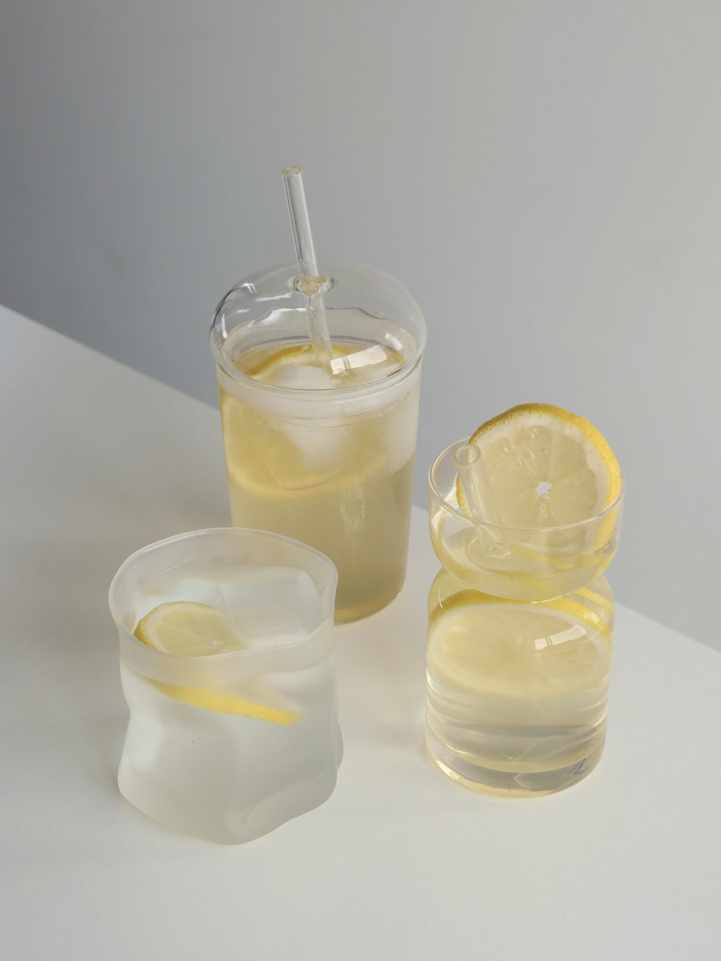 Glass cup, glass straw, clear drinkware, minimalist design, eco-friendly, reusable straw, modern tableware, transparent glass, natural light, home organization, clutter-free, tidy space, kitchen aesthetics, sustainable lifestyle, simple decor, functional kitchenware, stylish beverage, organized living, peaceful environment, elegant glassware, curated home, clean surface, thoughtful design, eco-conscious, calm ambiance.