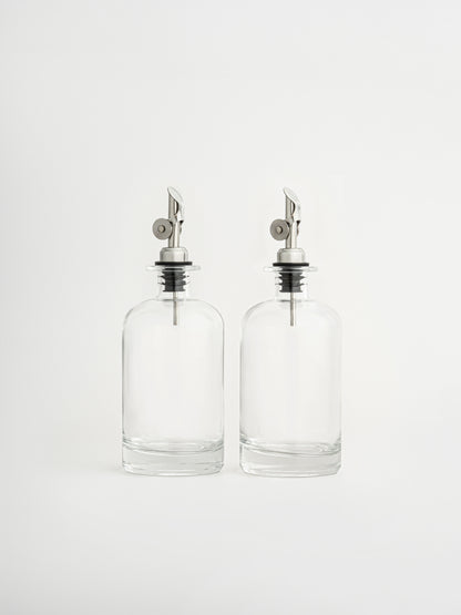 oil dispenser silver cap, vinegar dispenser silver spout, glass oil bottle, glass vinegar bottle, dispenser in two sizes, olive oil bottle, airtight oil container, silver pouring spout, non-drip oil dispenser, kitchen organizer bottle, elegant glass dispenser, modern kitchen accessory, pour control spout, oil and vinegar set, storage bottle for kitchen