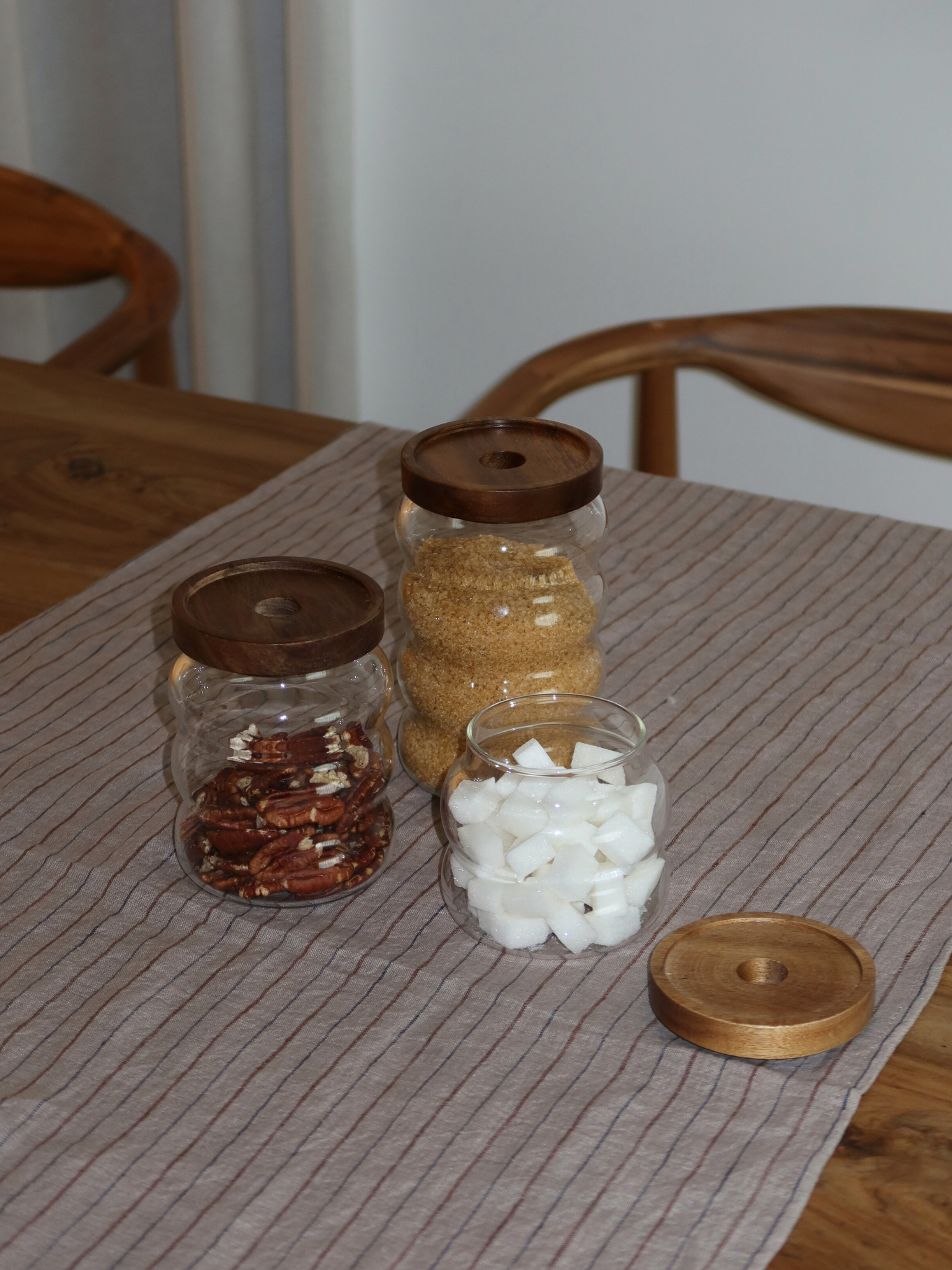 wavy round storage jar acacia lid, round storage jar with wavy shape, wavy glass storage jar, storage jar with acacia wooden lid, storage jar brown lid, storage jar with natural wooden lid, airtight storage jar, storage jar stylish design, storage jar with screw lid, transparent storage jar, storage jar kitchen organizing, storage jar set, storage jar small and large, storage jar with label, storage jar bamboo alternative, storage jar kitchen cabinet, storage jar sustainable material